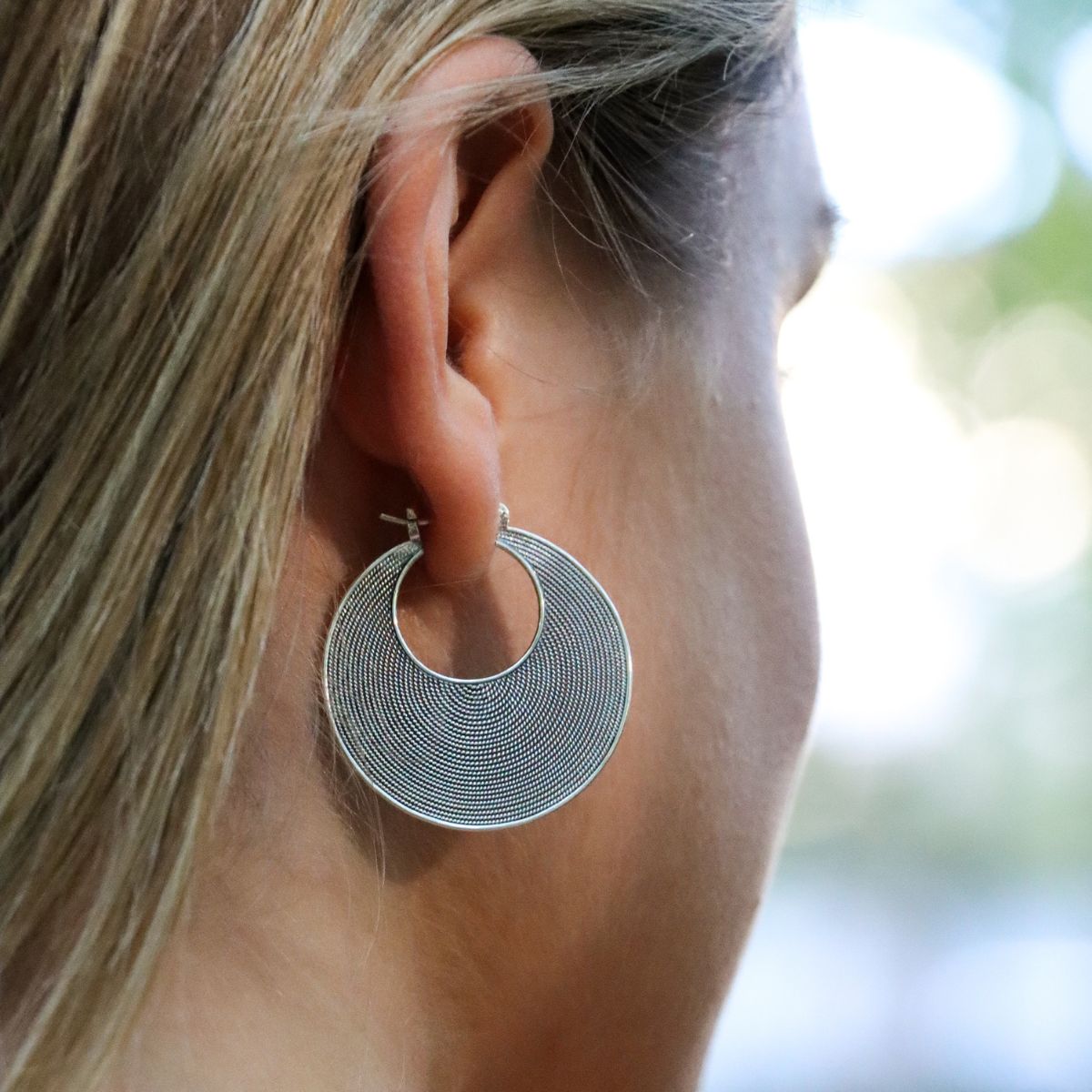 Closeup of model wearing Balinese boho chic hoops made of sterling silver