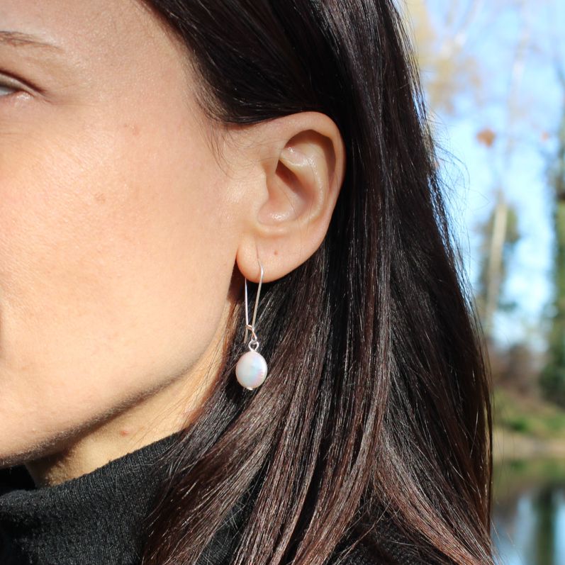 Closeup of model wearing bohemian boho chic Haawy earrings made of sterling silver featuring freshwater pearls