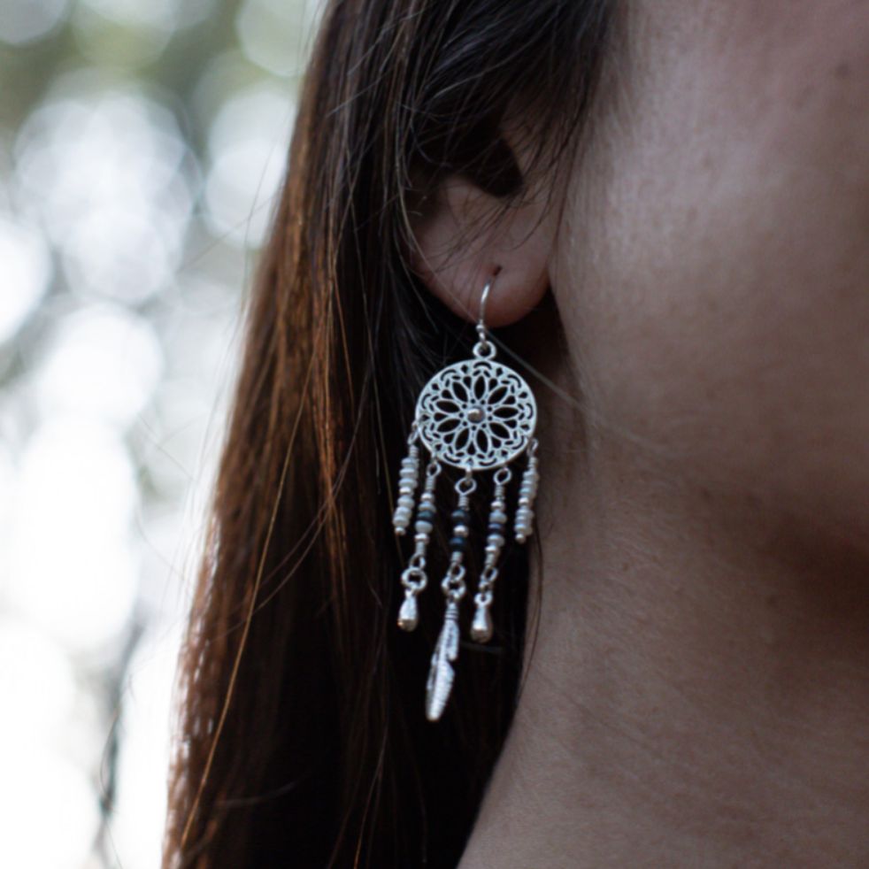 Model wearing sterling silver bohemian boho earrings featuring a dreamcatcher with pearls