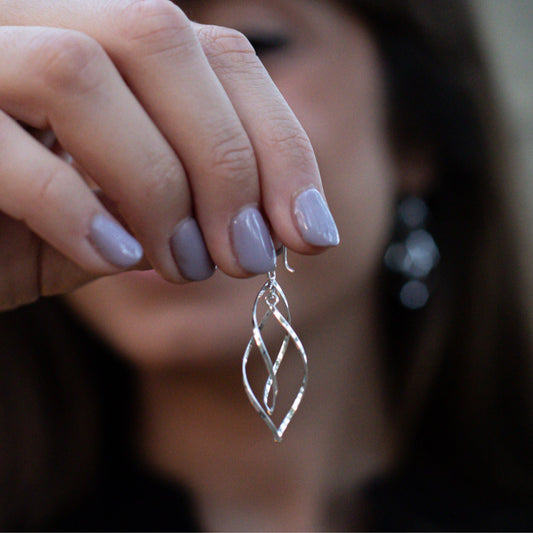 Boho chic Bai earrings made of genuine sterling silver held by model closeup