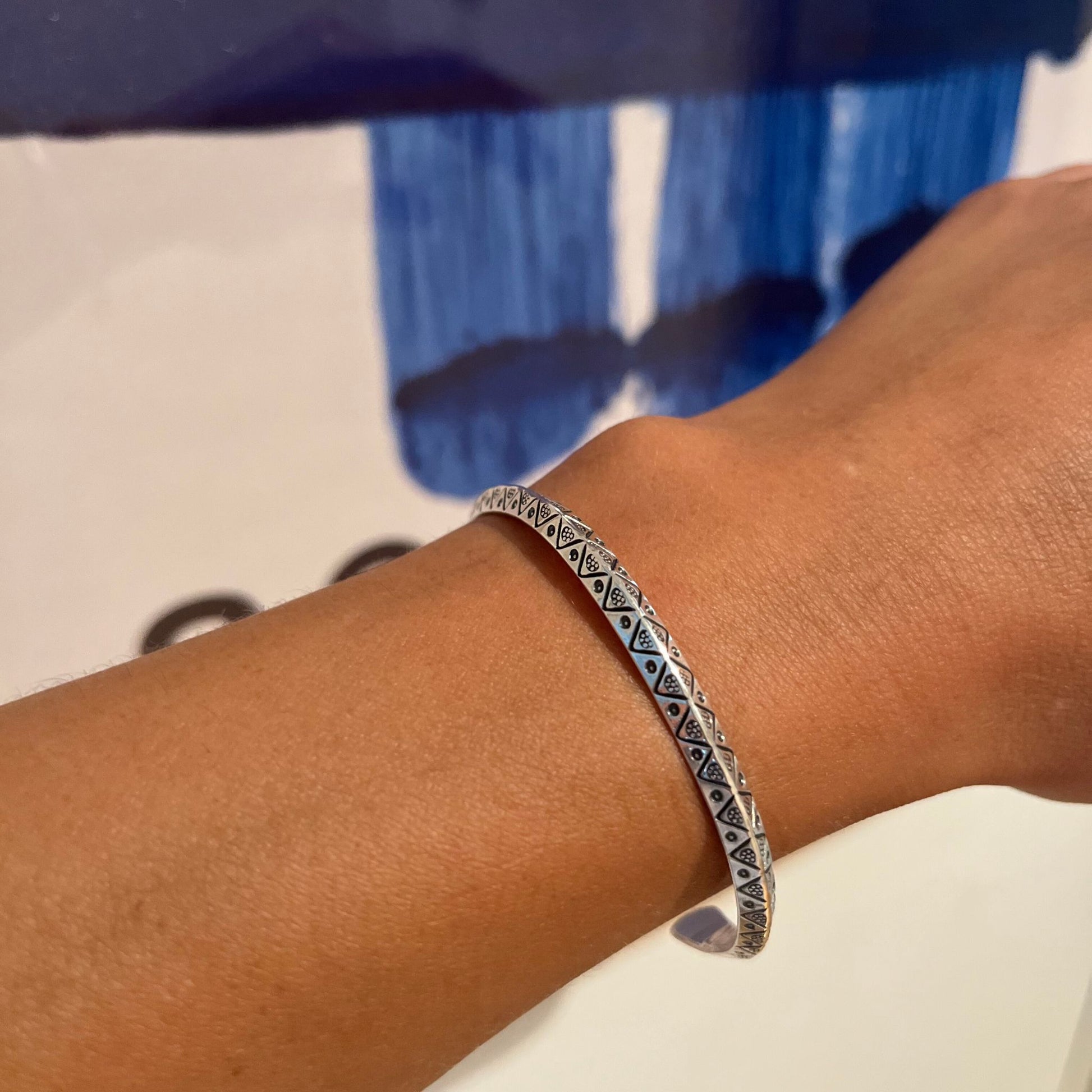 Handmade boho chic Hitee bangle made of sterling silver on model's left arm