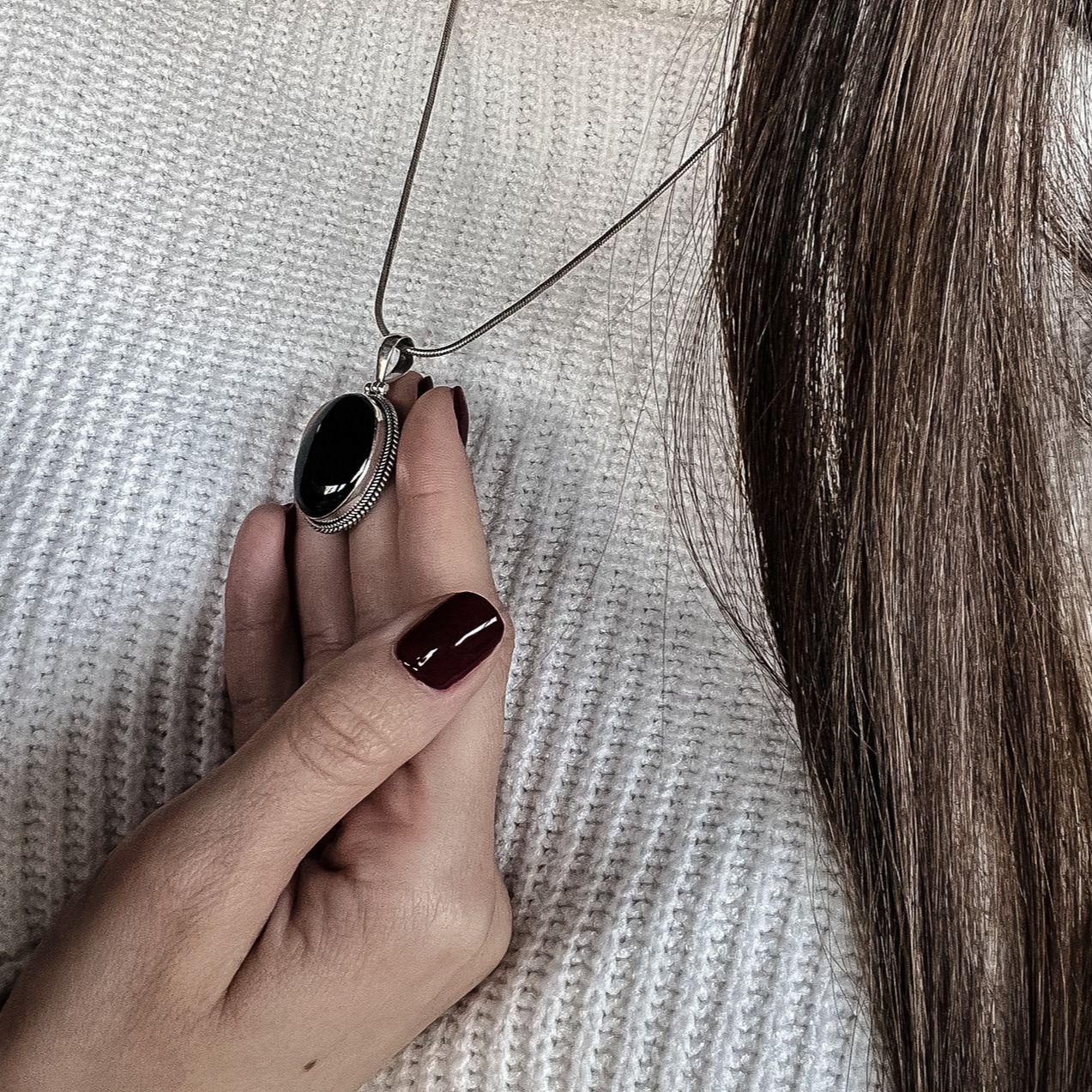 Model holding black agate bohemian boho chic pendant made from the natural gemstone and sterling silver