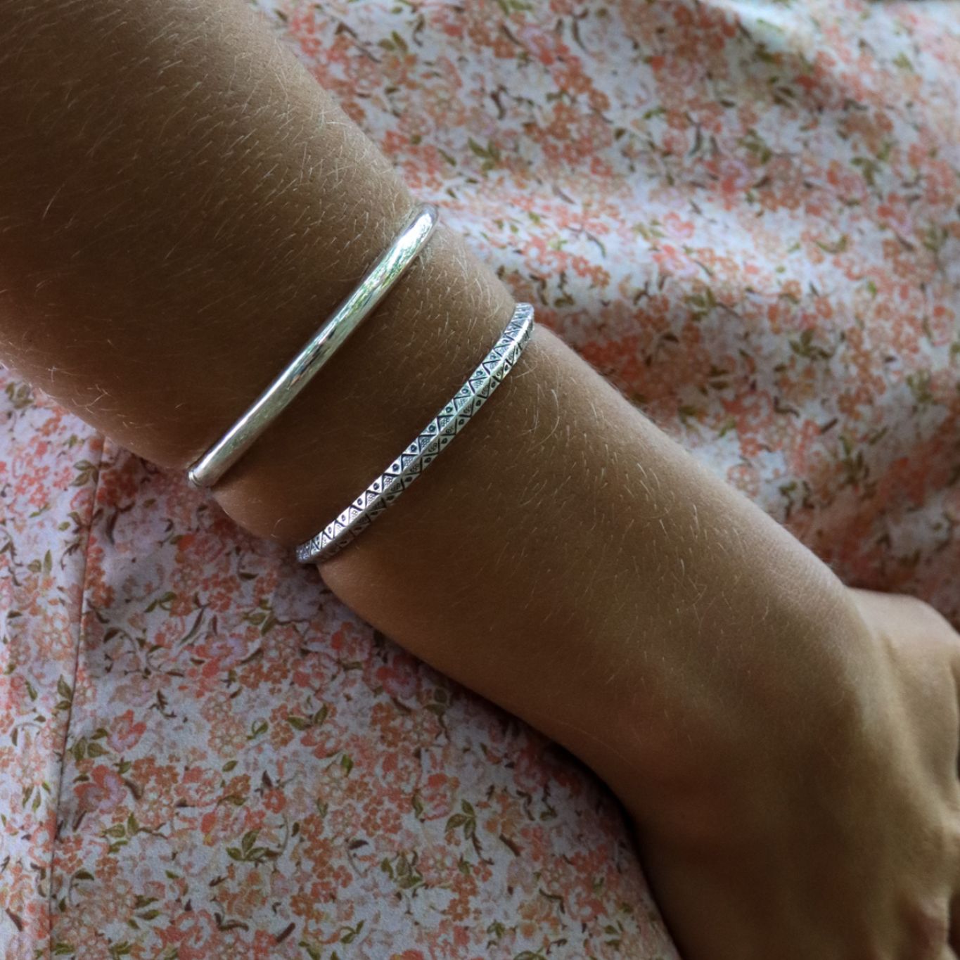 Handmade boho chic Hitee bangle made of sterling silver on model's right arm